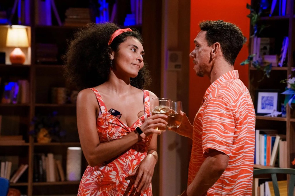 Actors Perry Mooney and Sean Dow perform a tense scene in Tiddas, standing close together with intense expressions. The background is dark, drawing focus to the emotional exchange between the two characters, captured mid-performance.