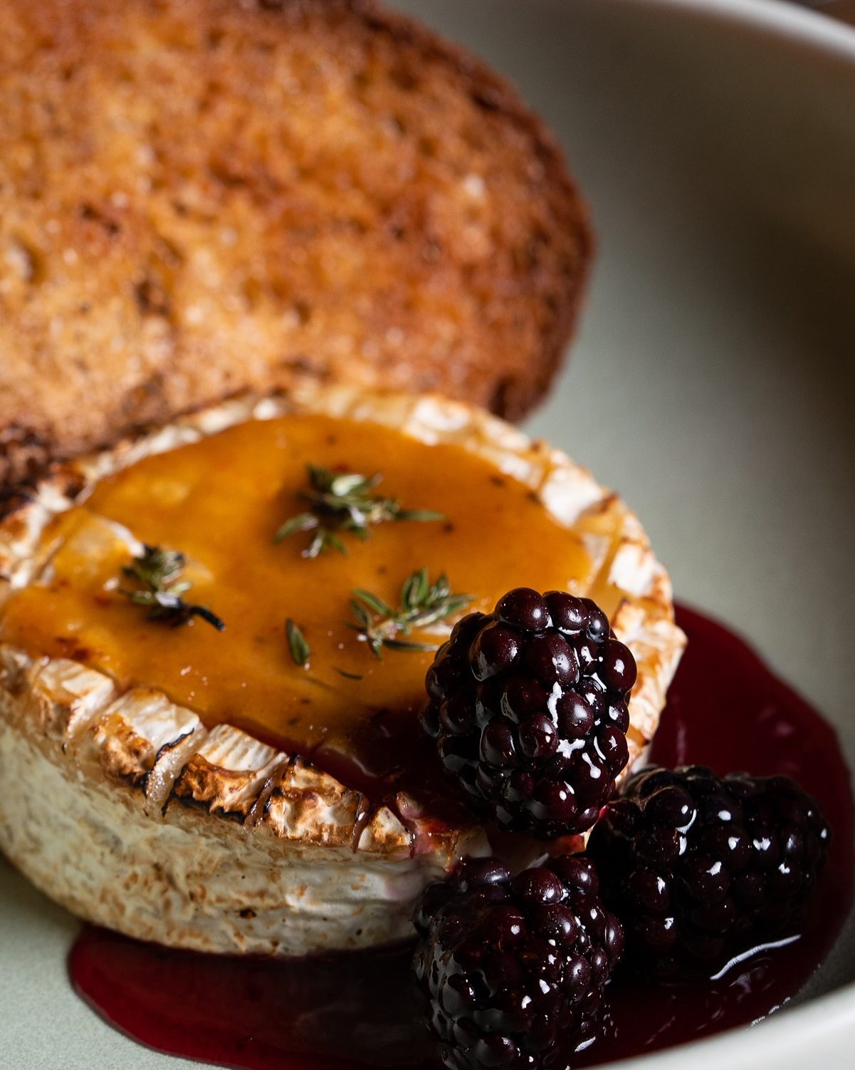 Gooey baked Camembert covered with honey and berries, with grilled bread
